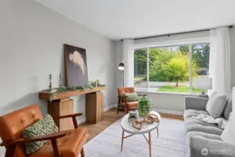 Love the large windows with pristine views of the pretty, green front yard.