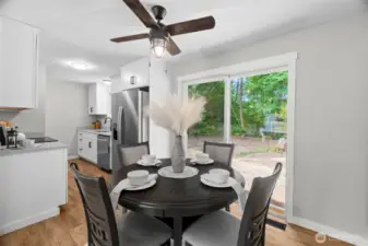 Dining Area with contemporary ceiling fan/light fixture and slider to backyard. Kitchen to the left and door to extra deep 1-car Garage on the right. (not pictured)