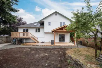 Fully-fenced back yard features an extensive deck