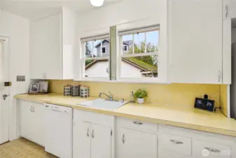 Kitchen window opens to a serene backyard.