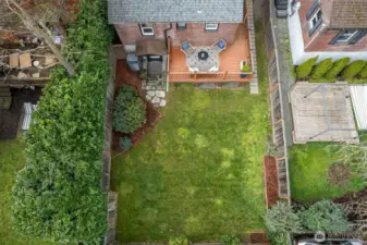 Elevated deck looking over fully-fenced lush green backyard.  Morning java?  Happy Hour?  Twilight al fresco dining?