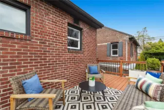 Elevated deck looking over fully-fenced lush green backyard.  Morning java?  Happy Hour?  Twilight al fresco dining?