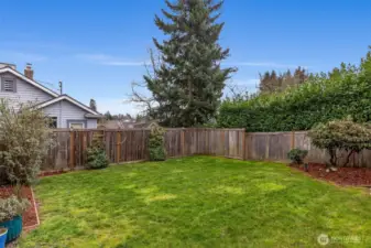 Elevated deck looking over fully-fenced lush green backyard.  Morning java?  Happy Hour?  Twilight al fresco dining?