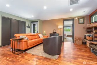 Spacious living room with view to primary bedroom, entry, and laundry behind 3 sliding doors.