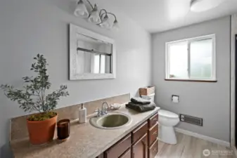 Hall bathroom renovated with new toilet and LVP.