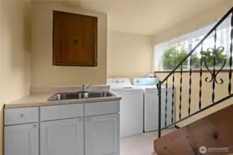 Backstairs from kitchen to the laundry room which is complete with divided sink.