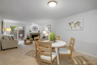 Here, the dining space flows effortlessly toward the patio and fireplace, illustrating how natural light and neutral tones enhance the home’s welcoming ambiance.