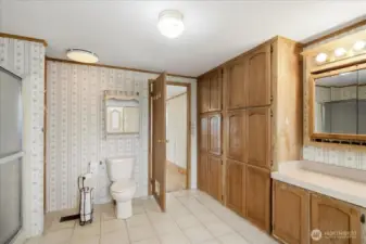 Bathroom attached to primary bedroom has lots of storage space.