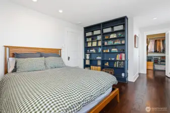 This is the Primary Suite located on the second floor. It features built-in bookcases, wide plank flooring a walk-in closet and its own 3/4 bathroom.