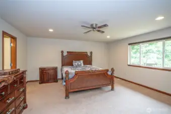This additional view of the primary suite highlights its large windows, bringing in abundant natural light.