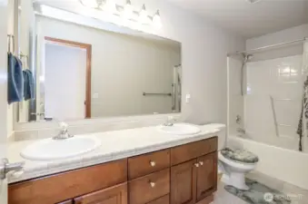 Spacious full guest bath on the upper level, complete with dual sinks for everyday ease.