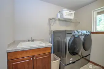 Smartly situated on the upper level, the utility room includes a useful sink and cabinetry for added functionality.
