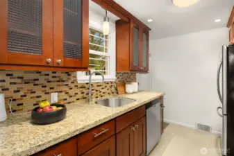 Updated kitchen with slab granite counters and ceramic tile floors.