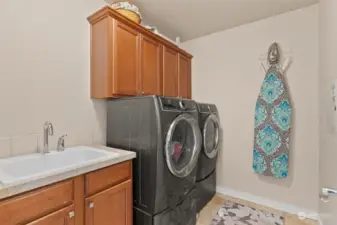 Upstairs laundry room with great stroage and laundry sink.