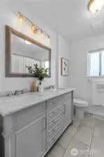 BATHROOM | The main bathroom in the home features double sinks, a tub and shower. New light fixtures make the space sparkle.