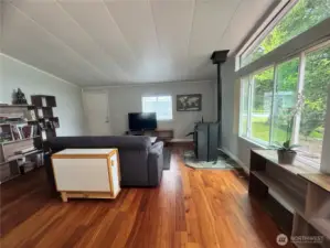 A view of the living room, from the kitchen. Here's the pellet stove. The heat pump provides Air Conditioning for these warm summer days, and efficient heat for winter.