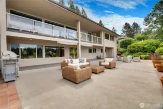 Rear facade of the home with spacious patio & covered deck.  Gas grill hookup and storage rooms under upper deck on both ends of the home.