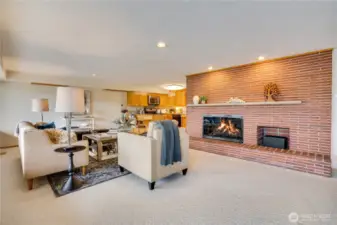 Gas fireplace on lower level with full hearth for additional seating.  Kitchen adjoins with eating bar.