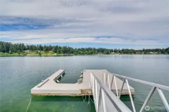 Aluminum ramp leads to large dock with synthetic deck boards.