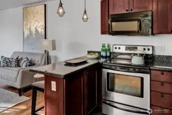 An eat-in kitchen with granite bar opens to the living room