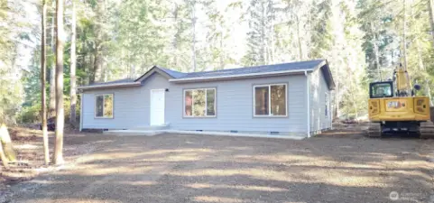 front of home with tractor in the front yard.  The home will be completed soon.  Get your sneak peak now.