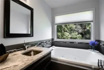 Primary bathroom with jetted tub to relax. Stamped metal double sinks plus granite counters