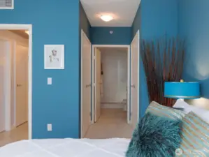 From primary bedroom leading to bathroom, two large closets with custom closet system on either side of hall.