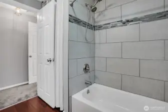 Custom tile work surrounds the shower/tub.