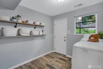A well-functioning laundry/mudroom area with convenient access door to the backyard.