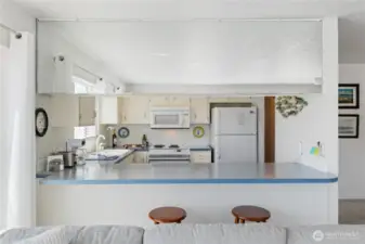 Kitchen with water views, room to sit and eat at the bar.  Clean, white and bright!