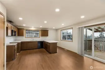 Open kitchen has been updated & offers breakfast bar + slider to back covered deck area.