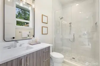 Ensuite bathroom features a floor-to-ceiling tiled shower stall with a built-in niche for storage.