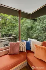 Glass-to-glass corner windows overlooking the dock and creek