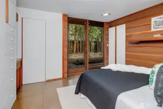 Primary suite with half bathroom and glass doors that open to garden space