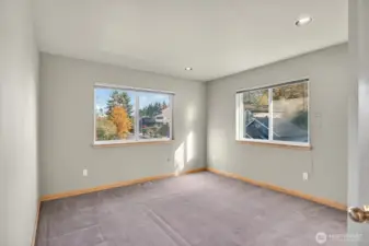 Upstairs bedroom flooded with light and colorful views.