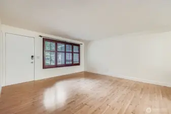 Open and bright formal living area with coat closet and linen closet. Engineered hardwood floors and fresh paint.