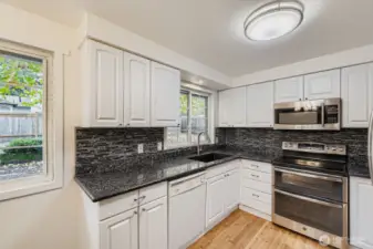 Updated kitchen with newer stainless appliances, granite counters, undermount lighting and extra deep sink.