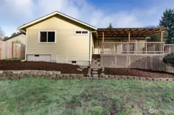Side view of home has terraces landscaping and oversized covered deck.