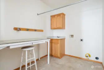Large laundry room with work table included near garage.