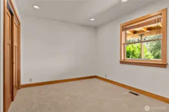 First floor bedroom with space for a queen bed and desk.