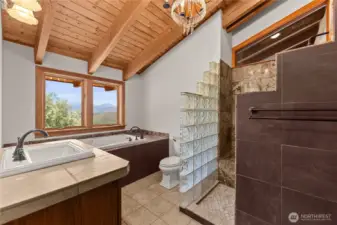 On-suite full bath with a dynamic mix of wood, tile and glass.
