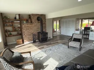 Great room with brick wall and built ins surrounding the wood stove that will keep you cozy in the winter