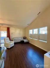 Vaulted ceilings and multiple windows offering natural light adorn the open concept living area.