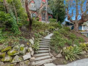 The winding stone path ushers you up to the home which is tucked into the lush landscaping. (Don't worry, there's level parking and entry in back!)