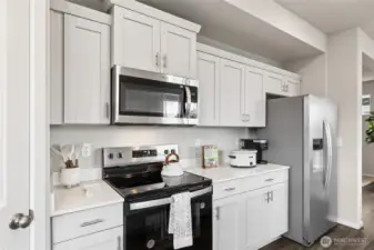 Stainless steel appliances and shaker style cabinets in your new kitchen. Photo is representational. Actual home is under construction. Colors, materials, and features may vary. See site agent for details.