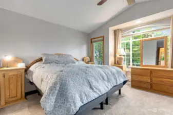 Spacious primary bedroom with ceiling fan, vaulted ceiling, walk-in closets and en-suite bathroom