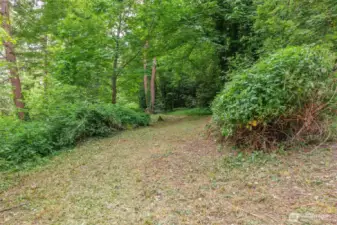 Lush trees and shrubs maintain privacy.