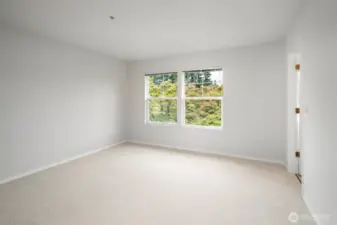 Generously sized master bedroom with sunlight streaming through windows