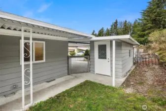 Showing shed and access to carport from backyard.