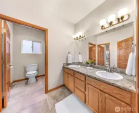 This bathroom connects to a bedroom on the left and another entrance from the hallway. Double sinks and bathtub/shower in the toilet room.
